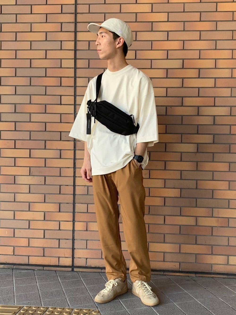 ホワイト系のTシャツ/カットソー、ブラック系のボディバッグ/ウエストポーチ、イエロー系のその他パンツを着用したメンズの夏コーディネートの1枚目の写真