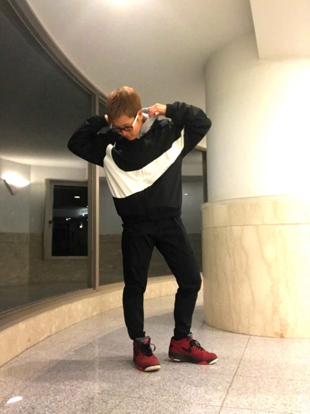 ブラック系のナイロンジャケット、グレー系のパーカー、ブラック系のその他パンツを着用したレディースの春コーディネートの1枚目の写真