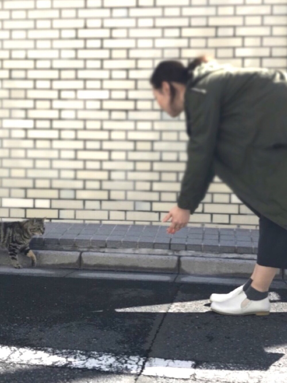 グリーン系のモッズコート、ホワイト系のシャツ/ブラウス、ブラック系のTシャツ/カットソーを着用したレディースの春コーディネートの1枚目の写真