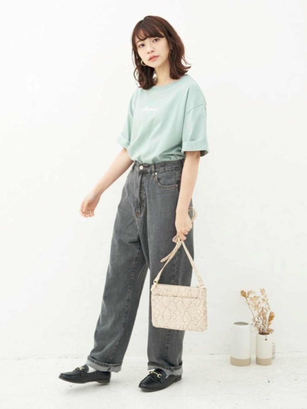 グリーン系のTシャツ/カットソー、ブラック系のデニムパンツを着用したレディースの春コーディネートの1枚目の写真