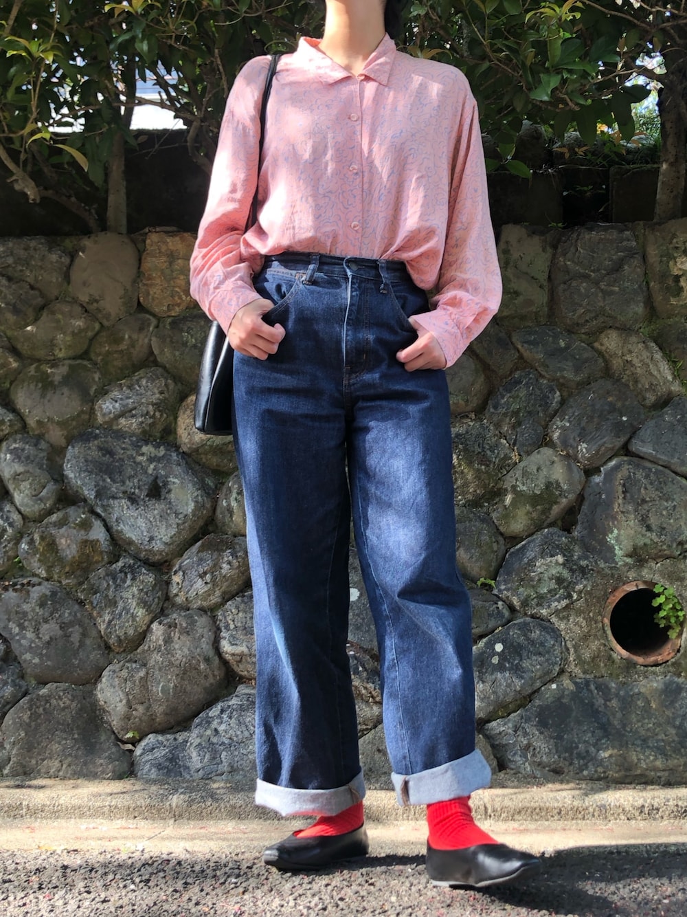 ブルー系のデニムパンツ、ブラック系のシューズ、ブラック系のショルダーバッグを着用したレディースの春コーディネートの1枚目の写真