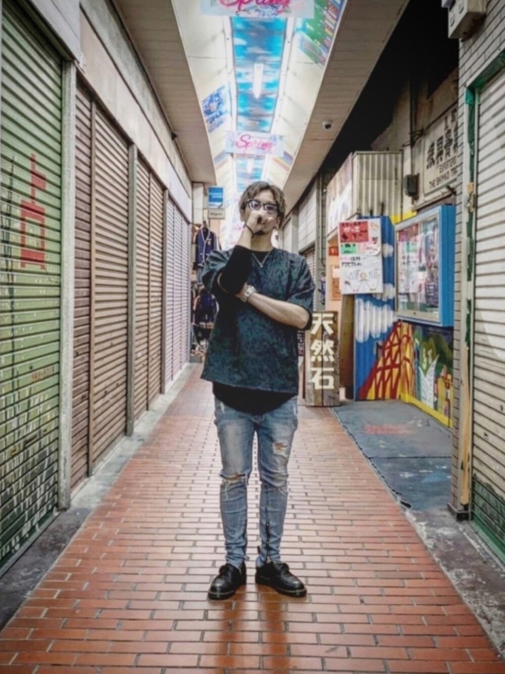 グリーン系のTシャツ/カットソー、ブルー系のデニムパンツ、ブラック系のブーツを着用したメンズの春コーディネートの1枚目の写真