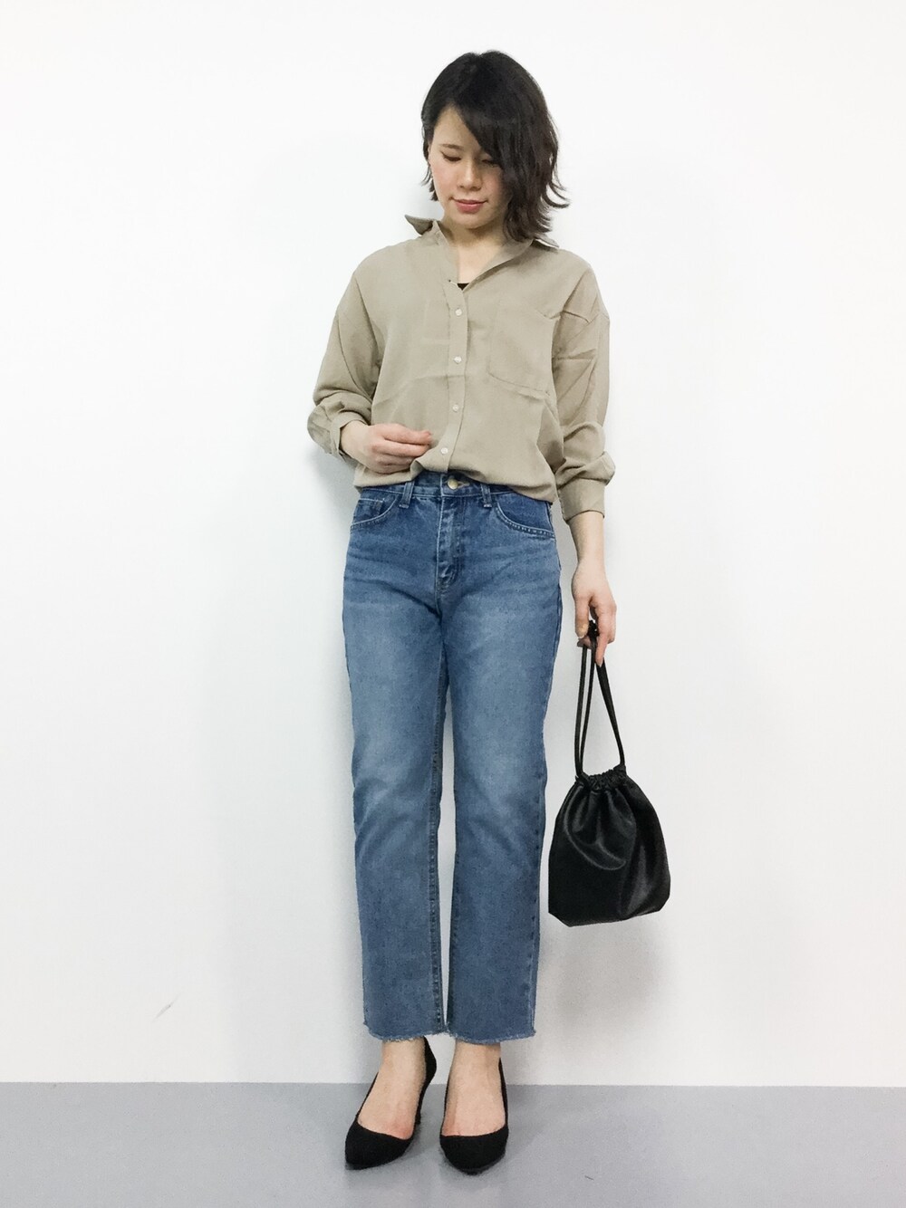 ベージュ系のシャツ/ブラウス、ブルー系のデニムパンツ、ブラック系のショルダーバッグを着用したレディースの春コーディネートの1枚目の写真