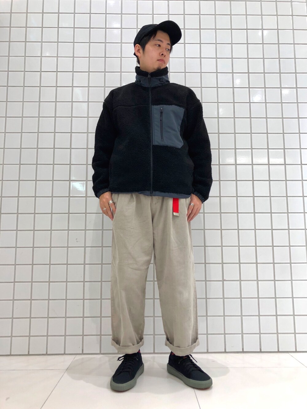 ブラック系のスニーカー、ブラック系のキャップを着用したメンズの冬コーディネートの1枚目の写真