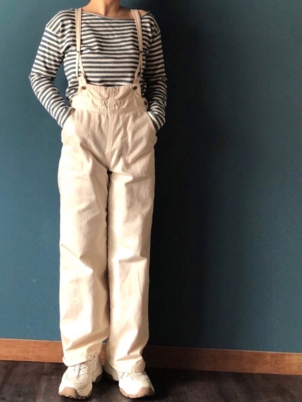 グリーン系のTシャツ/カットソー、ベージュ系のサロペット/オーバーオール、ベージュ系のスニーカーを着用したレディースの春コーディネートの1枚目の写真