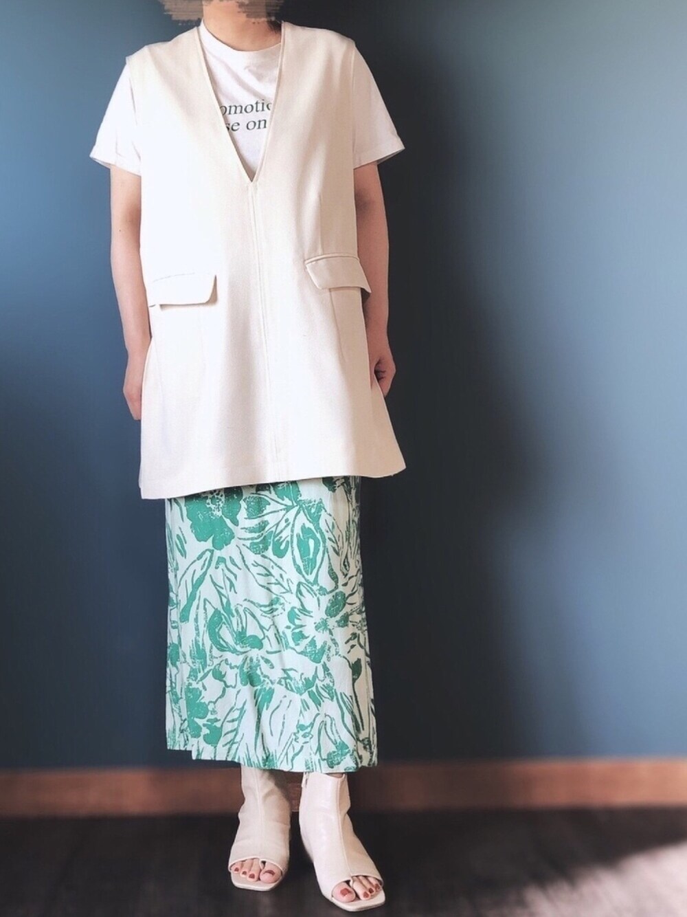 ベージュ系のTシャツ/カットソー、ホワイト系のベスト、グリーン系のスカートを着用したレディースの夏コーディネートの1枚目の写真