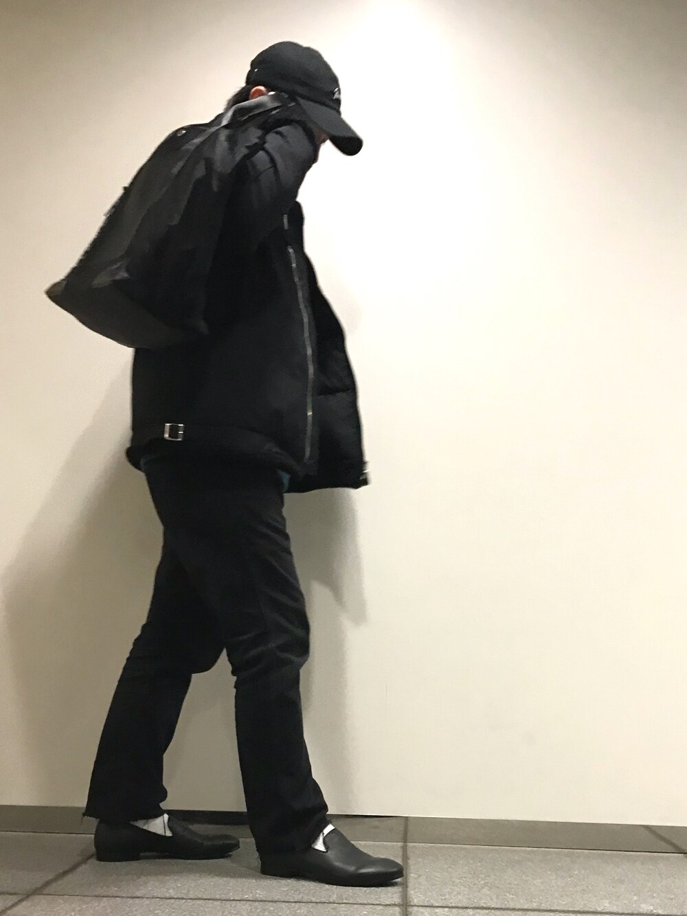 ブラック系のダウンジャケット/コート、ブルー系のニット/セーター、ブラック系のドレスシューズを着用したメンズの秋コーディネートの1枚目の写真