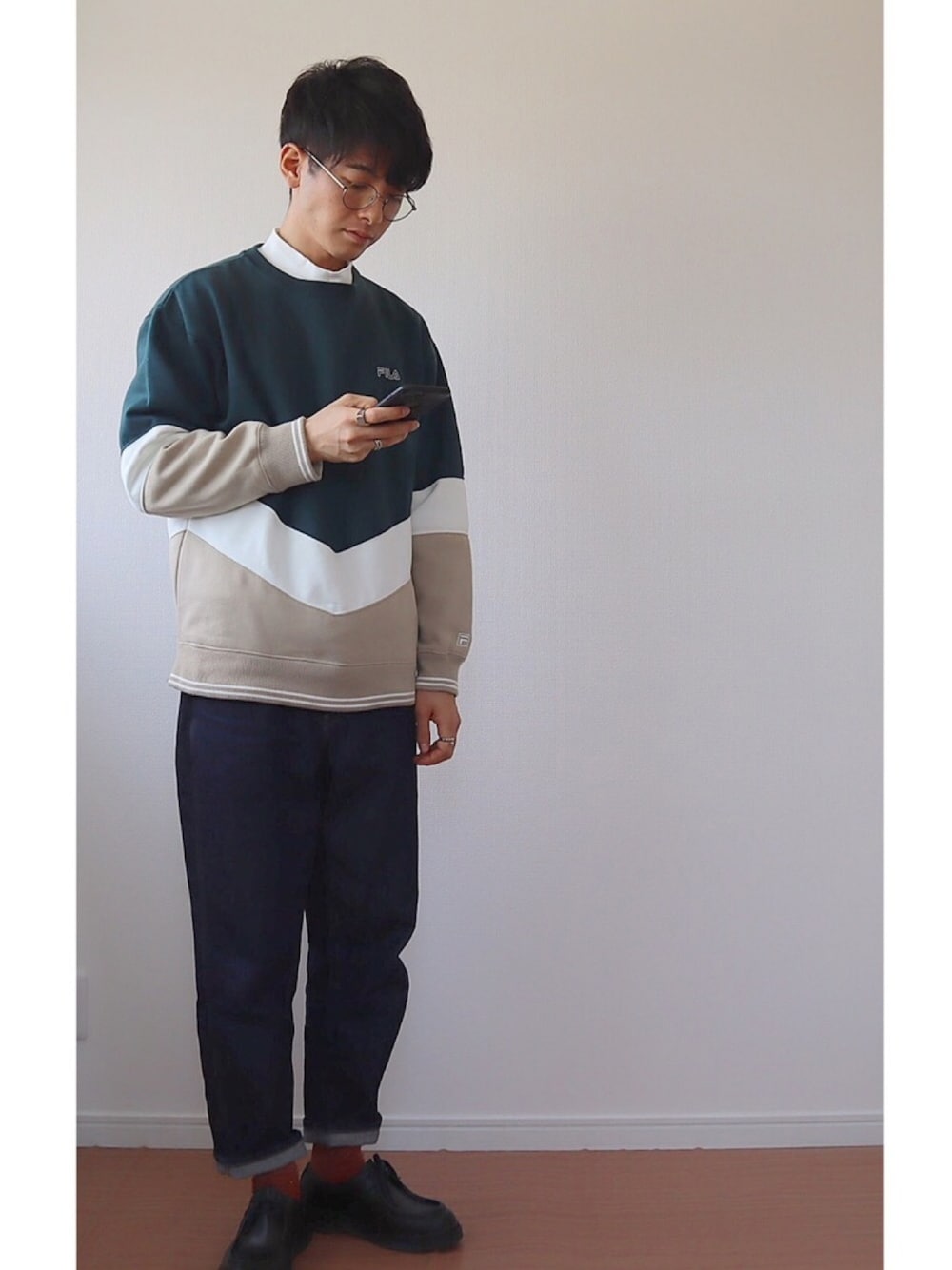 グリーン系のスウェット、ブルー系のデニムパンツ、ブラック系のその他シューズを着用したメンズの春コーディネートの1枚目の写真