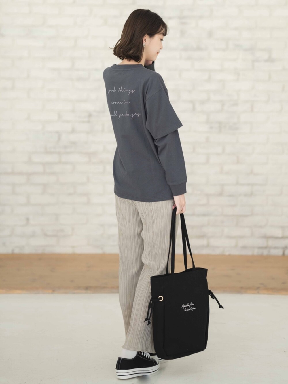 ブラック系のTシャツ/カットソー、グレー系のパンツ、ブラック系のトートバッグを着用したレディースの冬コーディネートの1枚目の写真