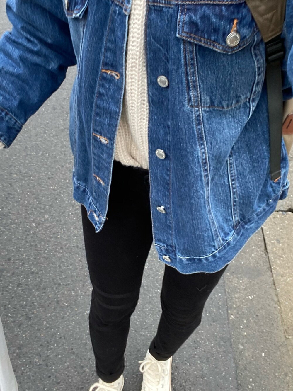 ブラック系のデニムパンツ、ベージュ系のスニーカー、ブルー系のデニムジャケットを着用したレディースの冬コーディネートの1枚目の写真