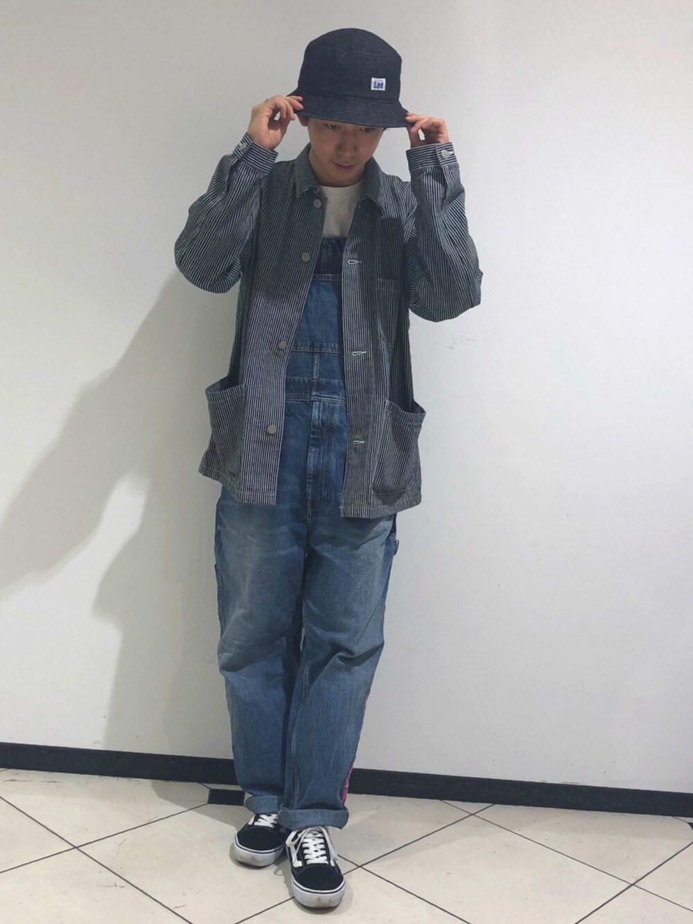 グレー系のデニムジャケット、ブルー系のサロペット/オーバーオール、ブルー系のハットを着用したメンズの秋コーディネートの1枚目の写真