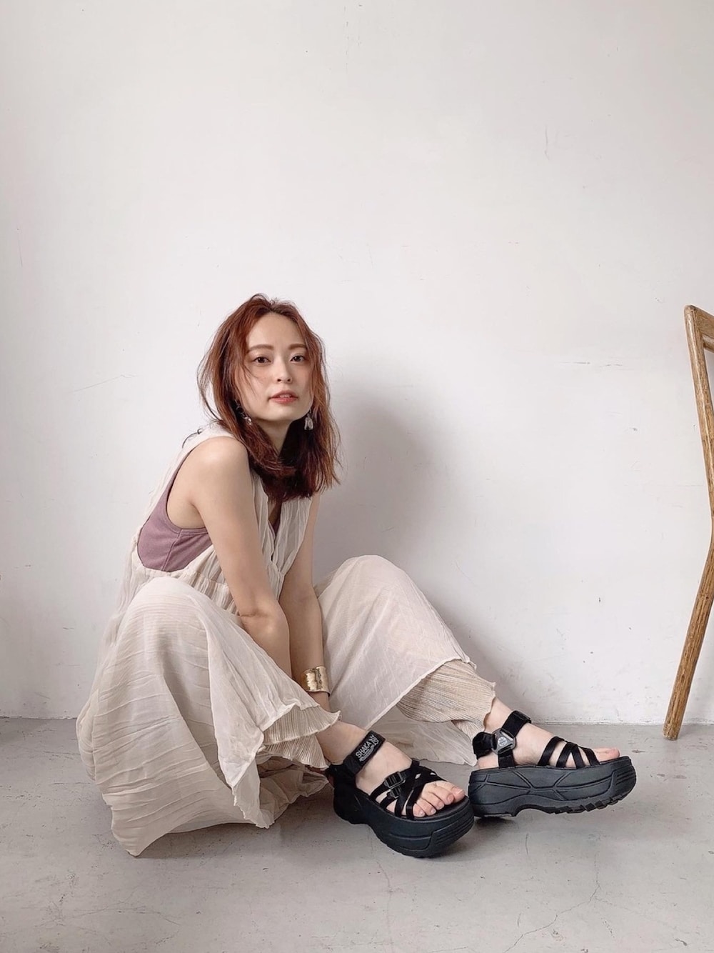 ベージュ系のパンツ、ブラック系のサンダルを着用したレディースの春コーディネートの1枚目の写真