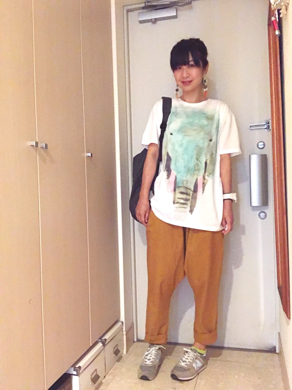 ホワイト系のTシャツ/カットソー、グレー系のバックパック/リュック、イエロー系のその他パンツを着用したレディースの春コーディネートの1枚目の写真