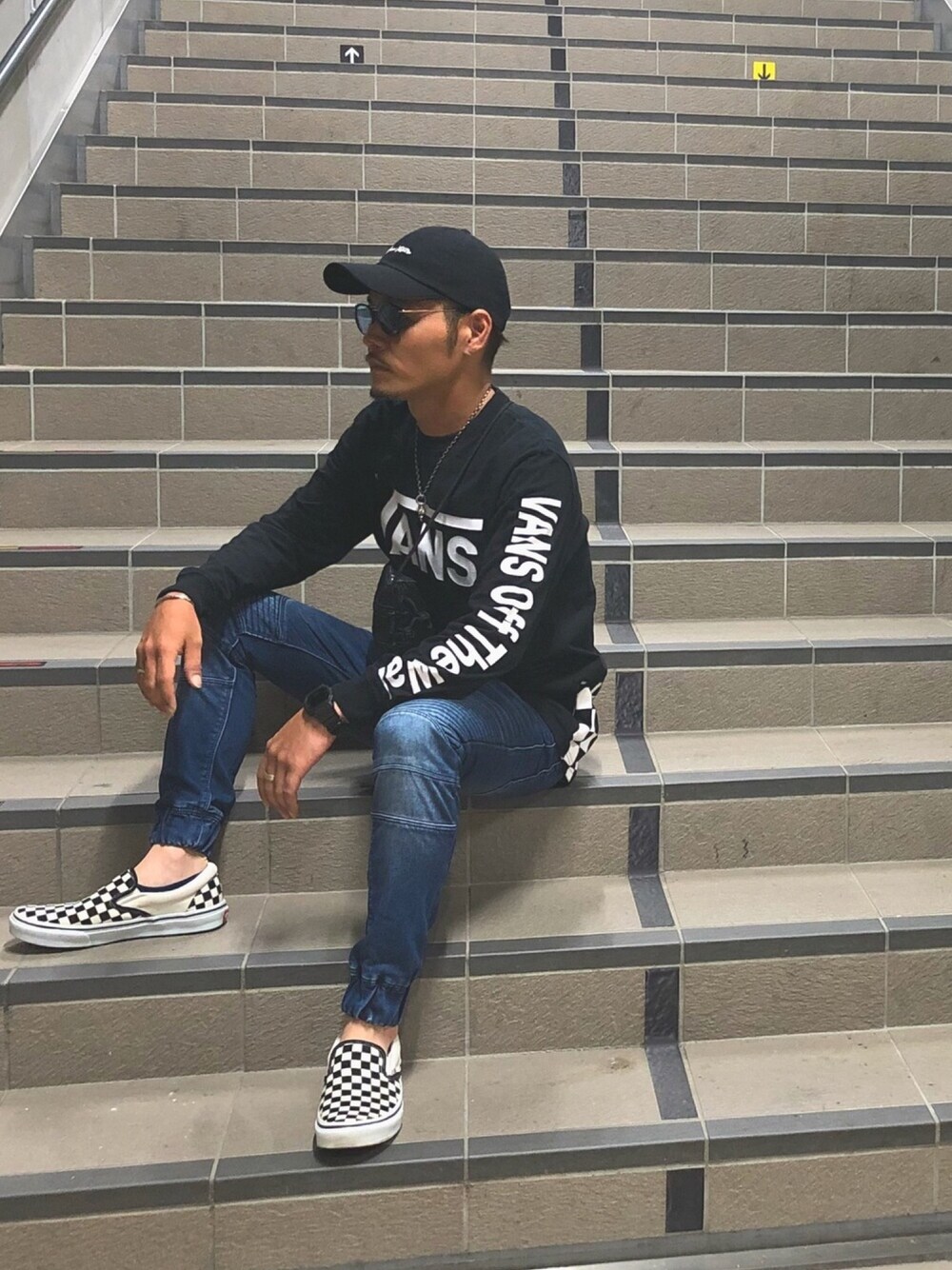 「チェッカーフラッグ祭り、秋コーデ、カジュアルコーデ、大人カジュアル、VANS、デニムパンツ、ロゴT、スリッポン、サングラス、キャップ」｜「VANSのアイテム（Tシャツ/カットソー、ブラック系）」を使った、takashi さん（メンズ・168cm）の夏コーディネートの1枚目の写真