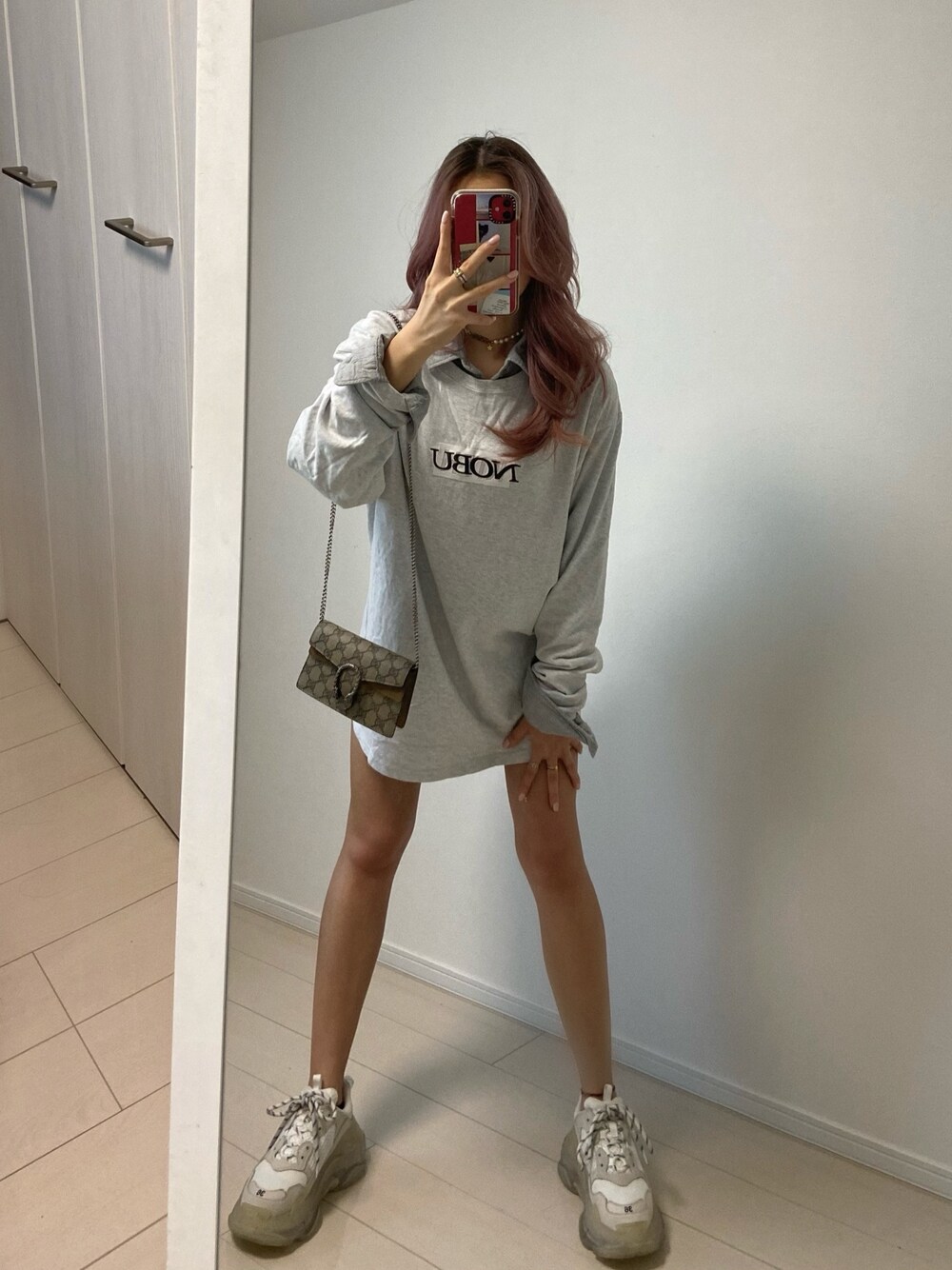 グレー系のトップス、ホワイト系のシューズ、ベージュ系のバッグを着用したレディースの秋コーディネートの1枚目の写真