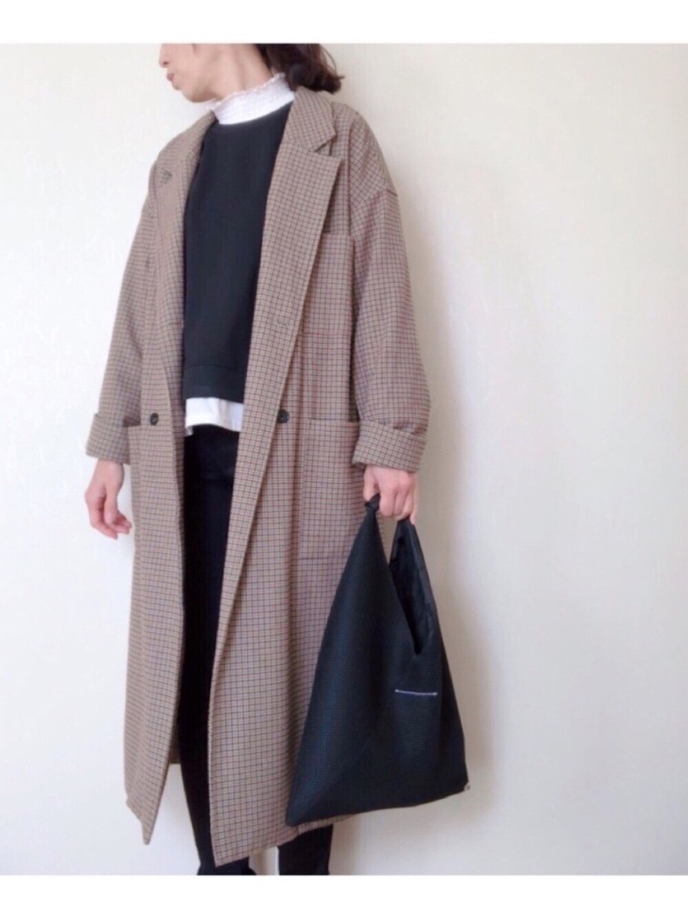 ブラック系のデニムパンツ、ブラック系のハンドバッグ、ブラウン系のその他アウターを着用したレディースの冬コーディネートの1枚目の写真