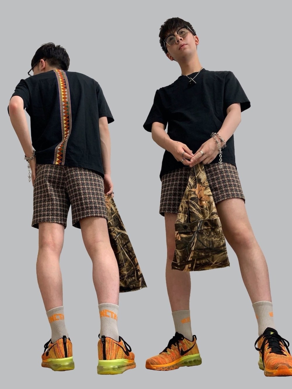 ブラック系のTシャツ/カットソー、ベージュ系のパンツ、ブラウン系のエコバッグ/サブバッグを着用したメンズの夏コーディネートの1枚目の写真