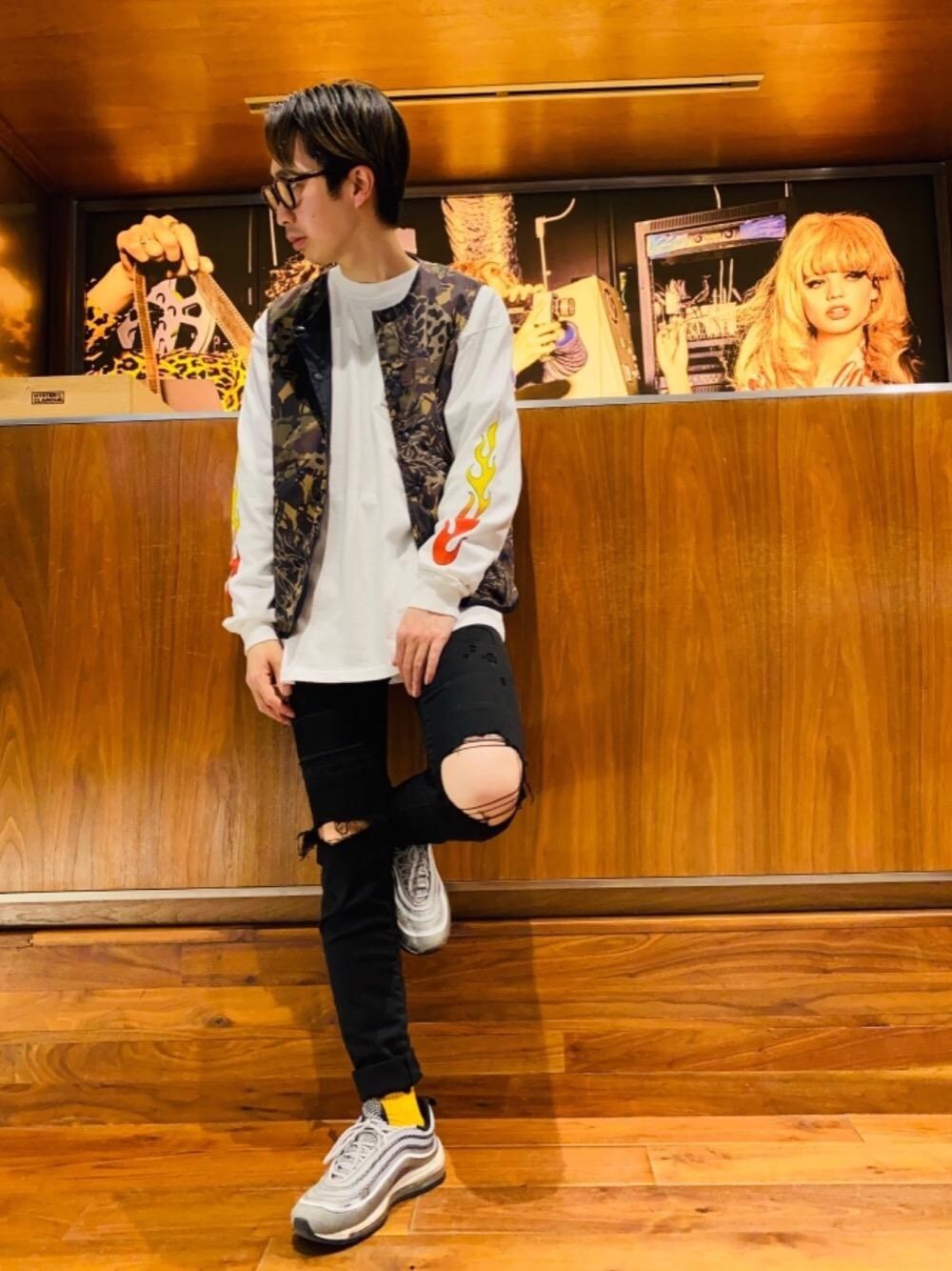 ブラック系のデニムパンツ、ホワイト系のTシャツ/カットソー、レッド系のミリタリージャケットを着用したメンズの春コーディネートの1枚目の写真