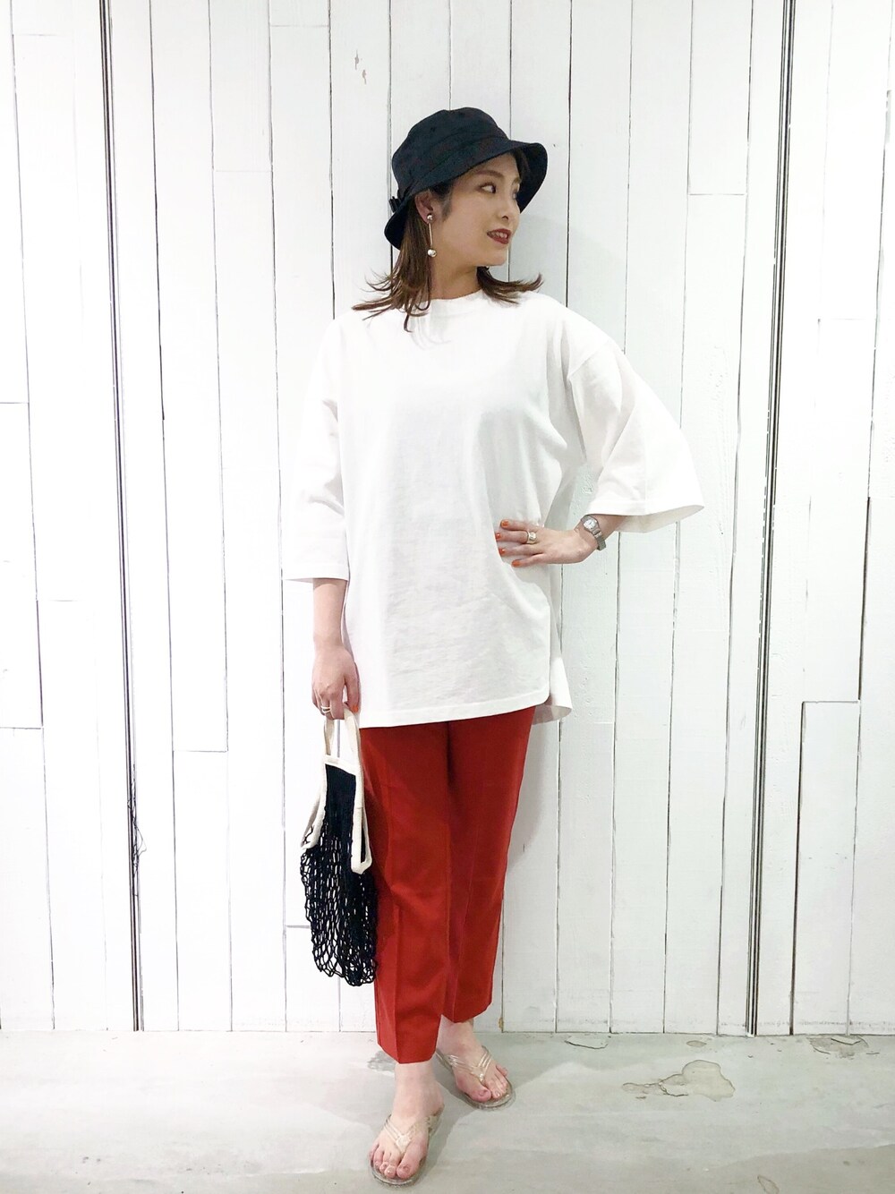 ホワイト系のTシャツ/カットソー、レッド系のスラックス、ブラック系のトートバッグを着用したレディースの春コーディネートの1枚目の写真