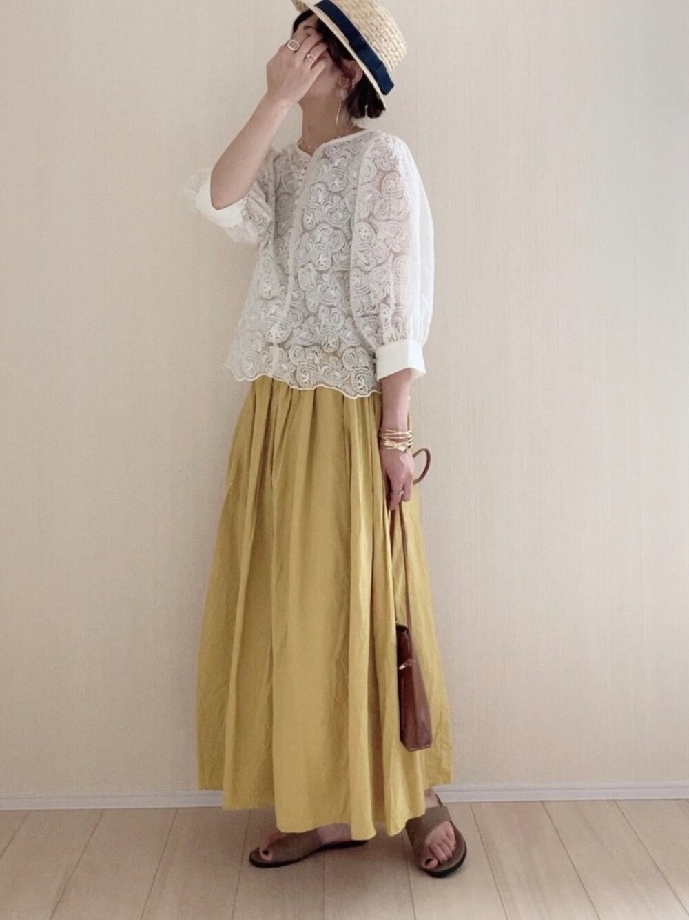 ベージュ系のシャツ/ブラウス、イエロー系のスカート、イエロー系のショルダーバッグを着用したレディースの夏コーディネートの1枚目の写真