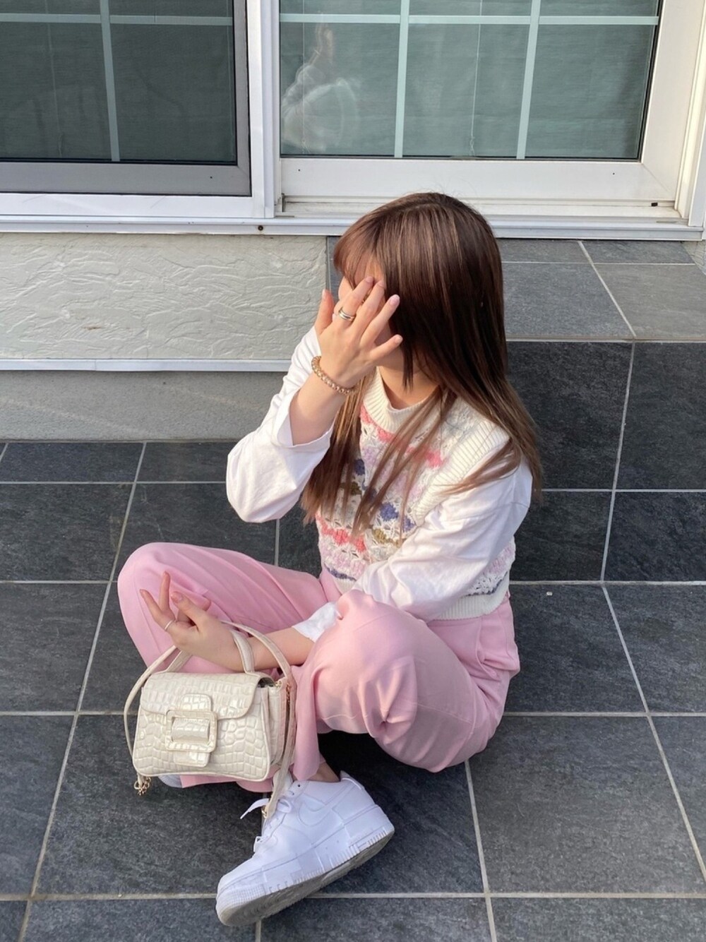 ピンク系のベスト、ホワイト系のTシャツ/カットソー、ピンク系のスラックスを着用したレディースの春コーディネートの1枚目の写真