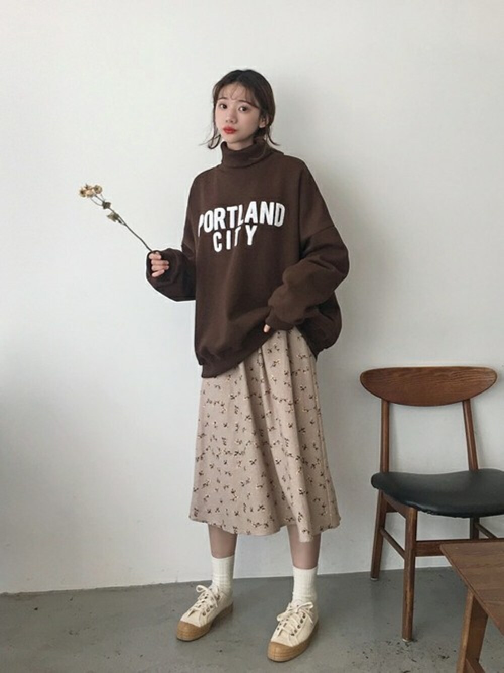 ベージュ系のワンピース、ブラウン系のスウェットを着用したレディースの冬コーディネートの1枚目の写真