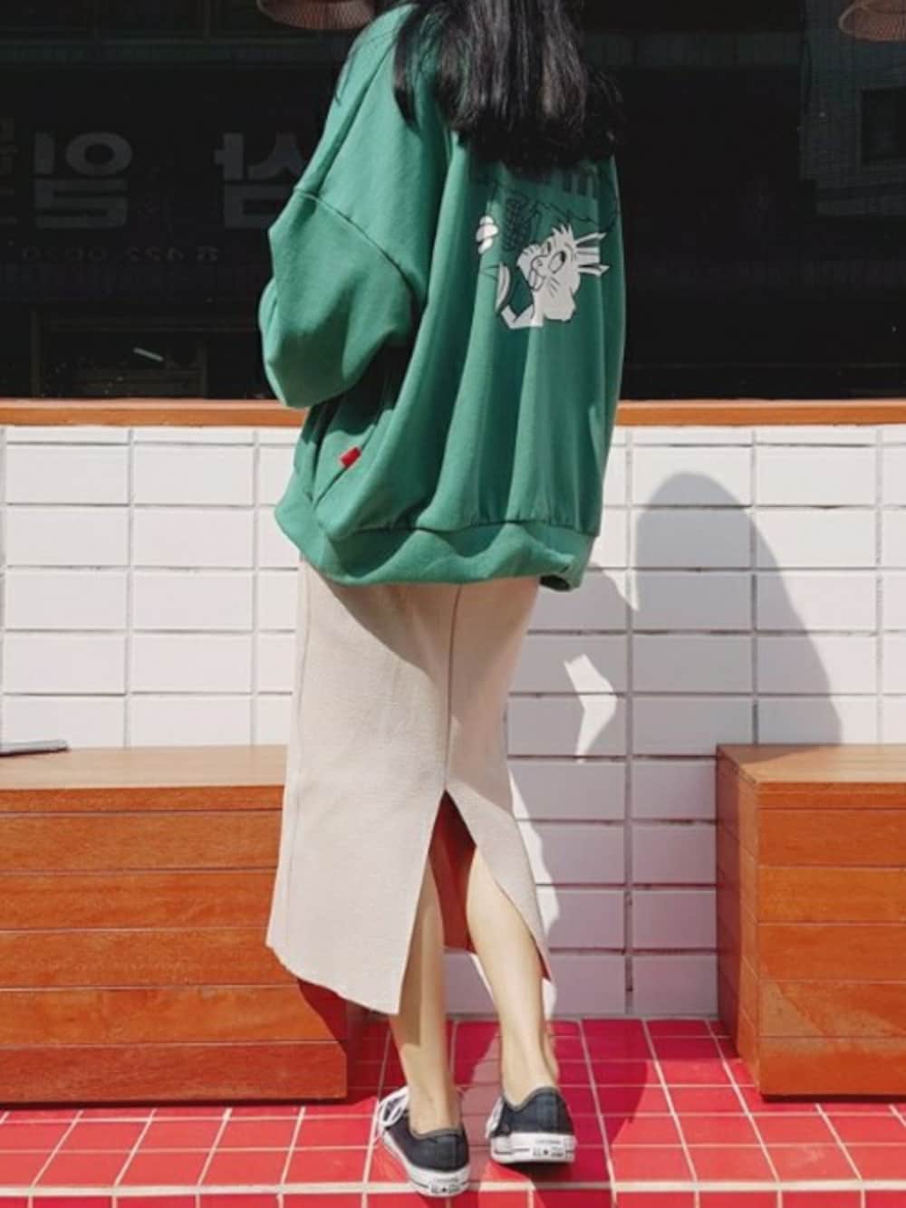 グリーン系のスウェット、ベージュ系のスカートを着用したレディースの秋コーディネートの1枚目の写真