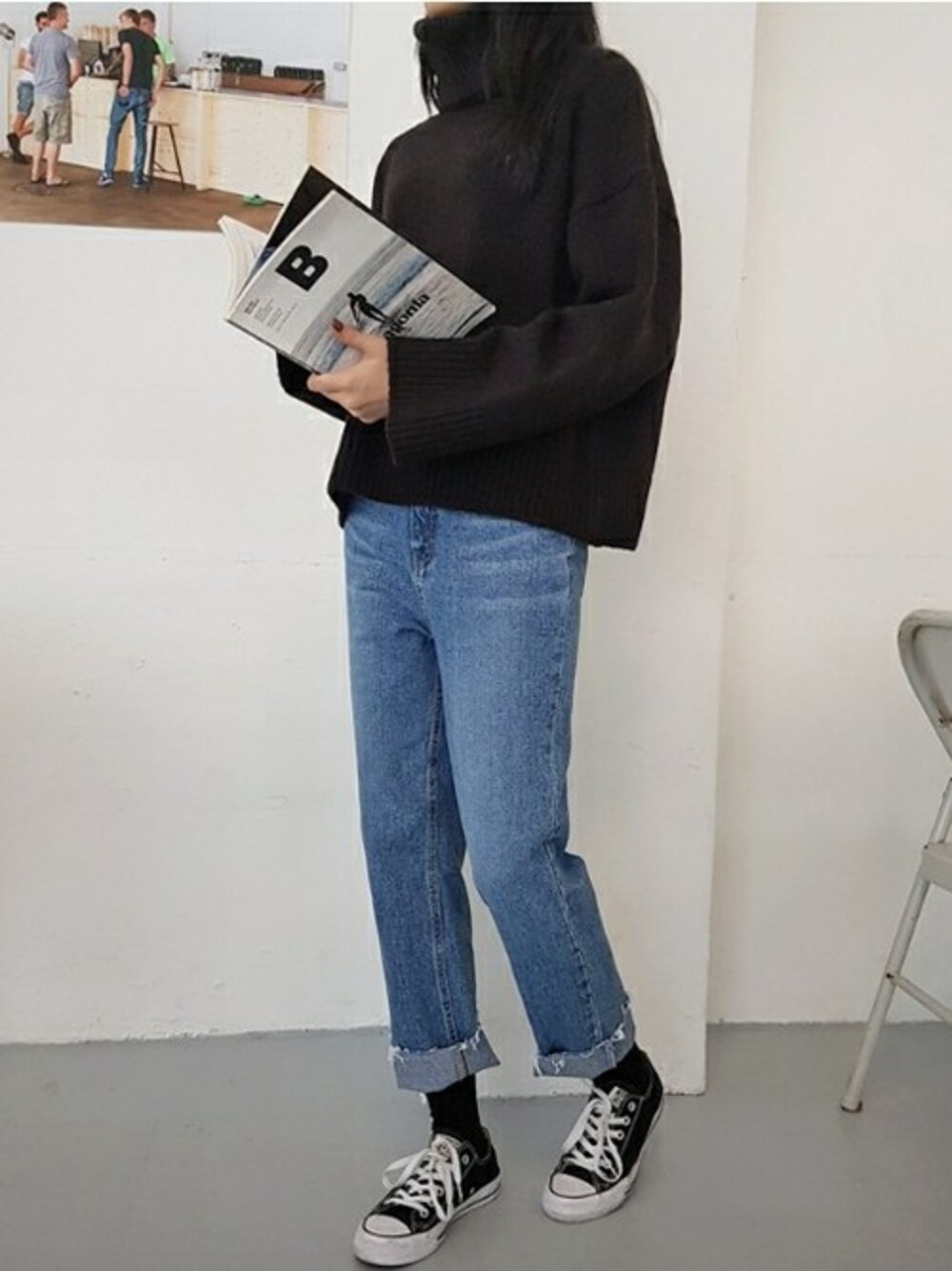 ブラック系のニット/セーター、ブルー系のデニムパンツを着用したレディースの秋コーディネートの1枚目の写真