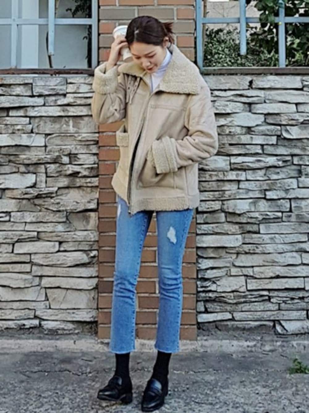 ベージュ系のムートンコート、ホワイト系のTシャツ/カットソー、ブラック系のローファーを着用したレディースの秋コーディネートの1枚目の写真