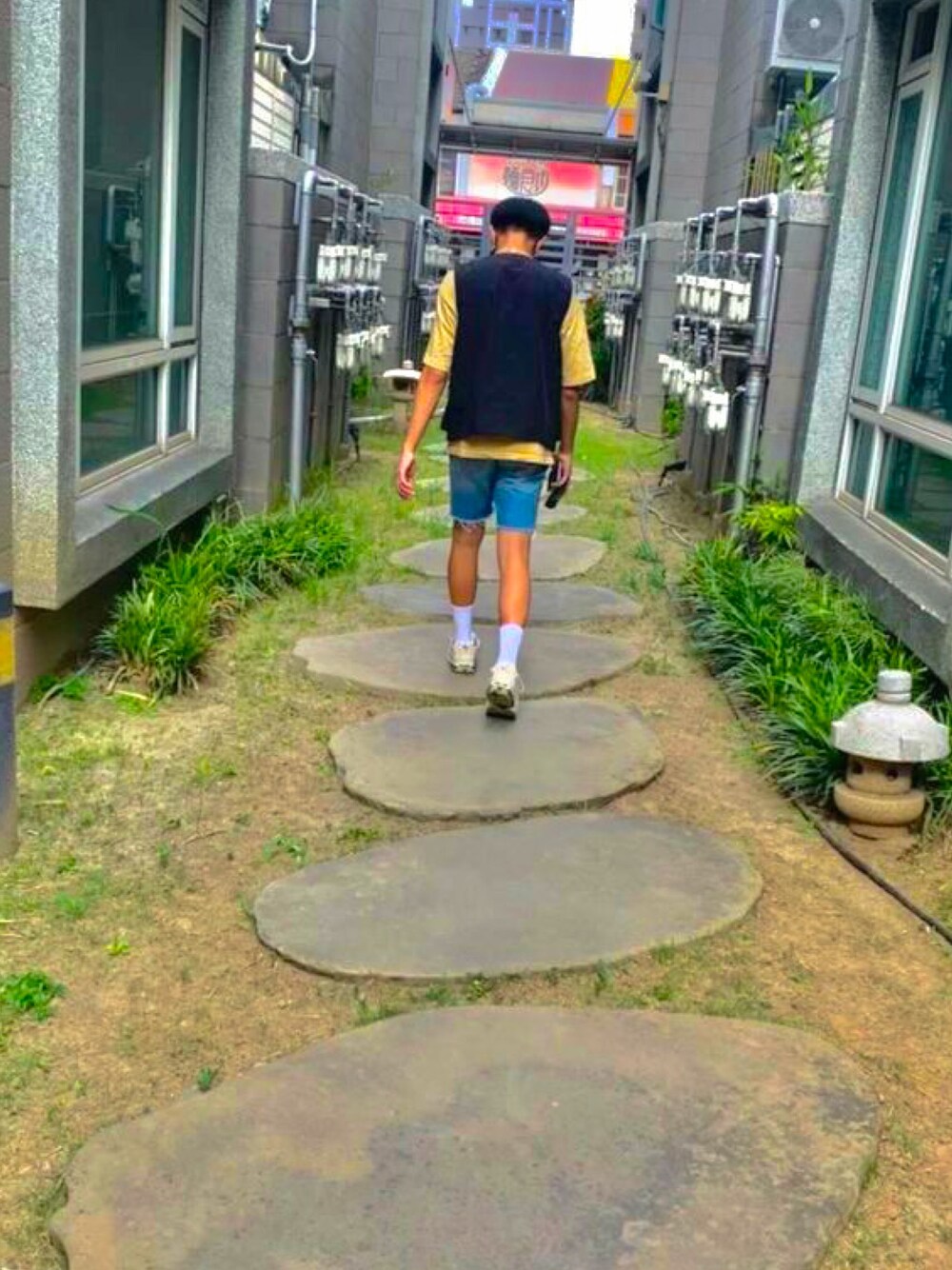 ベージュ系のTシャツ/カットソー、ブルー系のデニムパンツ、ベージュ系のスニーカーを着用したメンズの春コーディネートの1枚目の写真