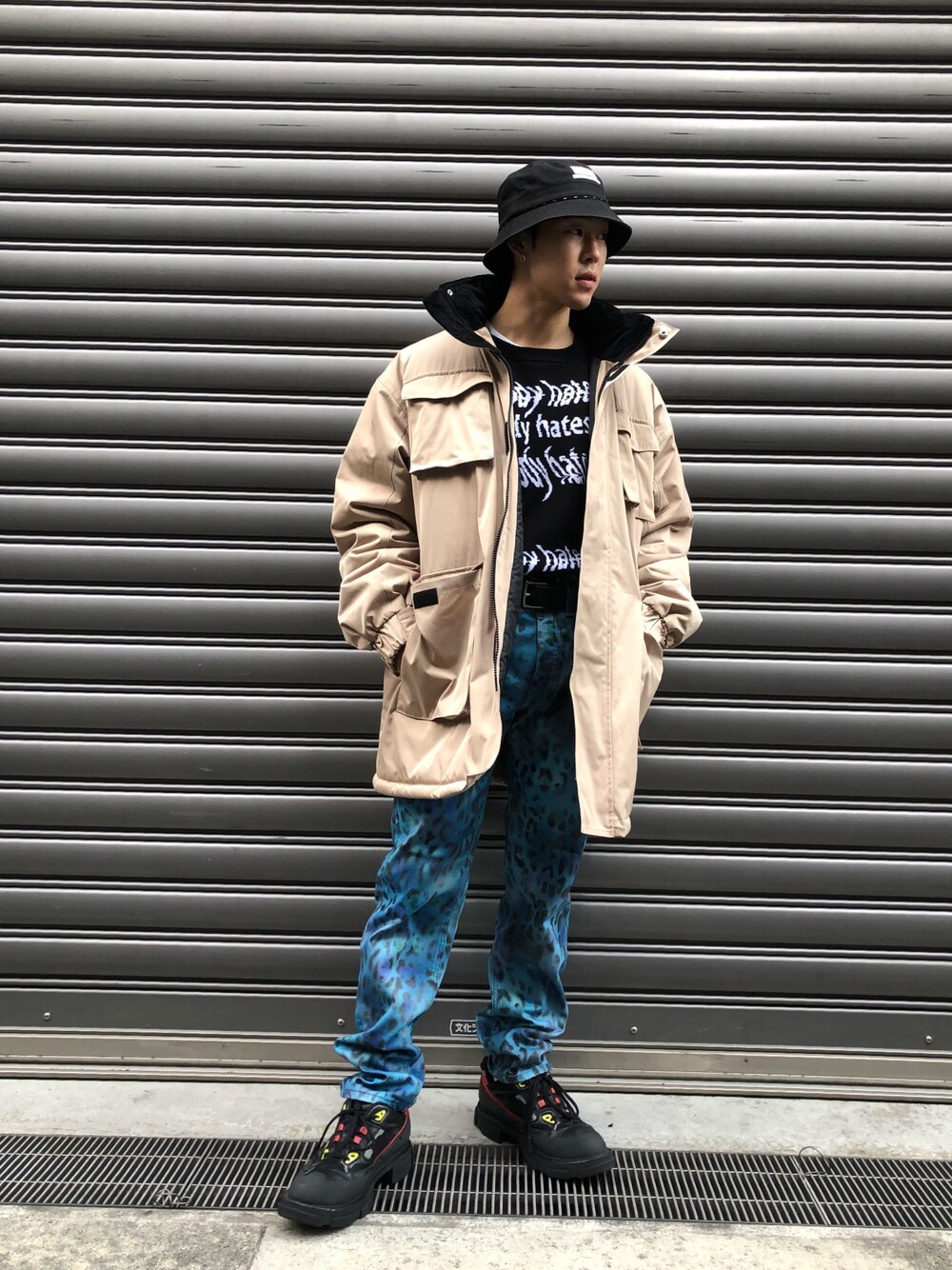 ベージュ系のミリタリージャケット、ブラック系のニット/セーター、ベージュ系のミリタリージャケットを着用したメンズの秋コーディネートの1枚目の写真