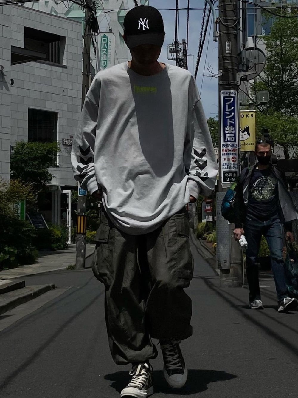 グレー系のTシャツ/カットソー、グリーン系のカーゴパンツ、グリーン系のスニーカーを着用したメンズの春コーディネートの1枚目の写真