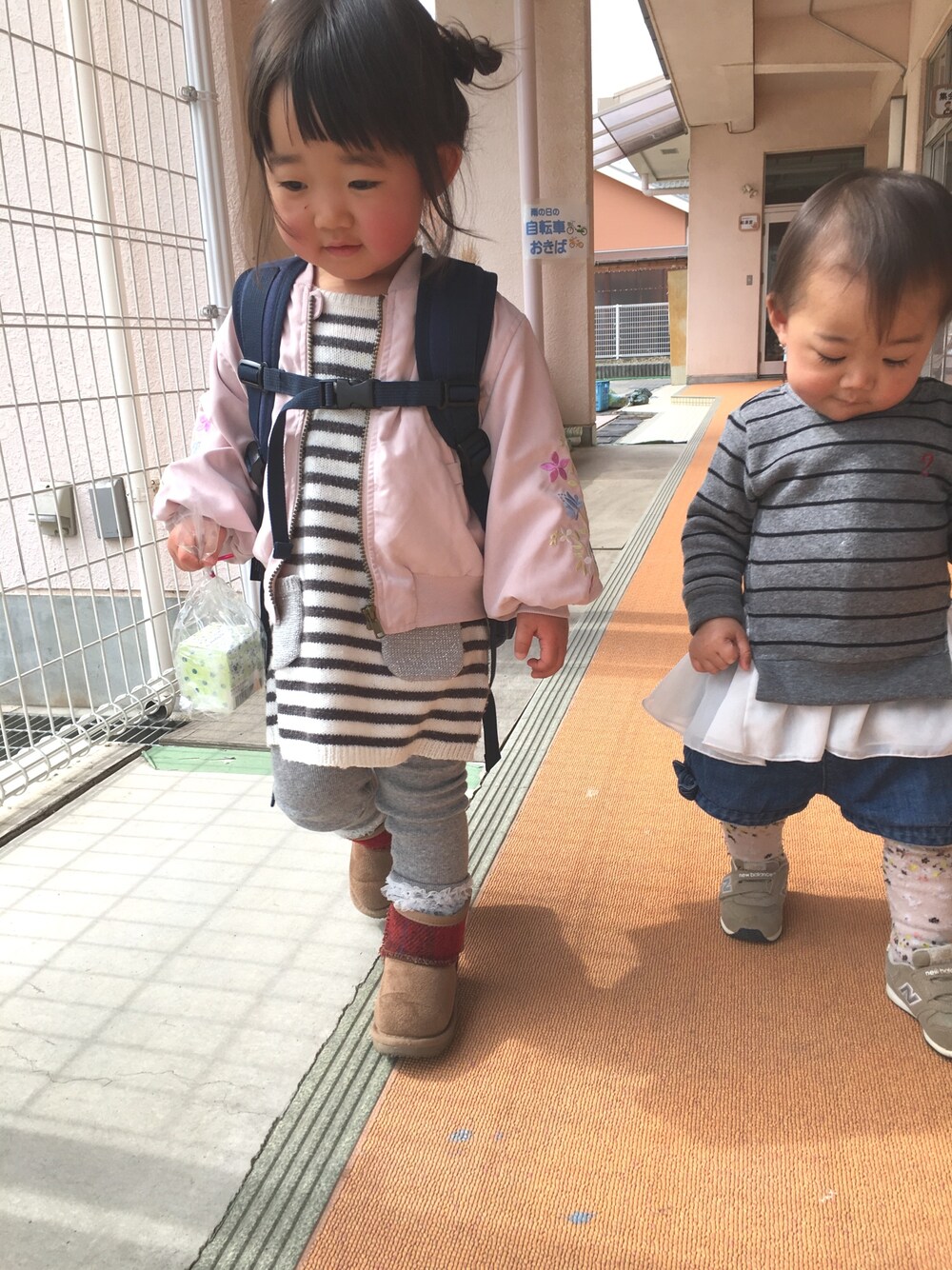 ピンク系のブルゾン、グレー系のワンピース、ベージュ系のブーツを着用したキッズの冬コーディネートの1枚目の写真