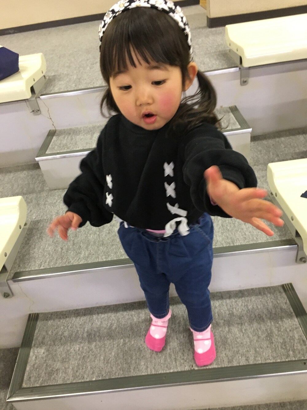 ブラック系のスウェット、ブルー系のデニムパンツ、ブラック系のヘアバンドを着用したキッズの春コーディネートの1枚目の写真