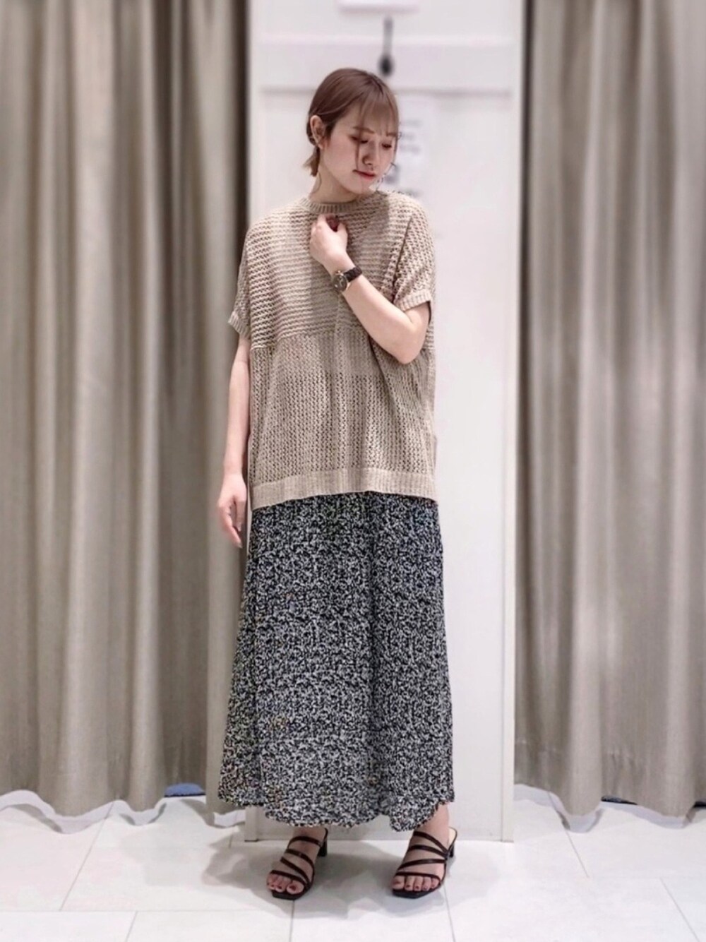 ブラック系のスカート、ブラック系のサンダル、ブラウン系のアンサンブルを着用したレディースの春コーディネートの1枚目の写真