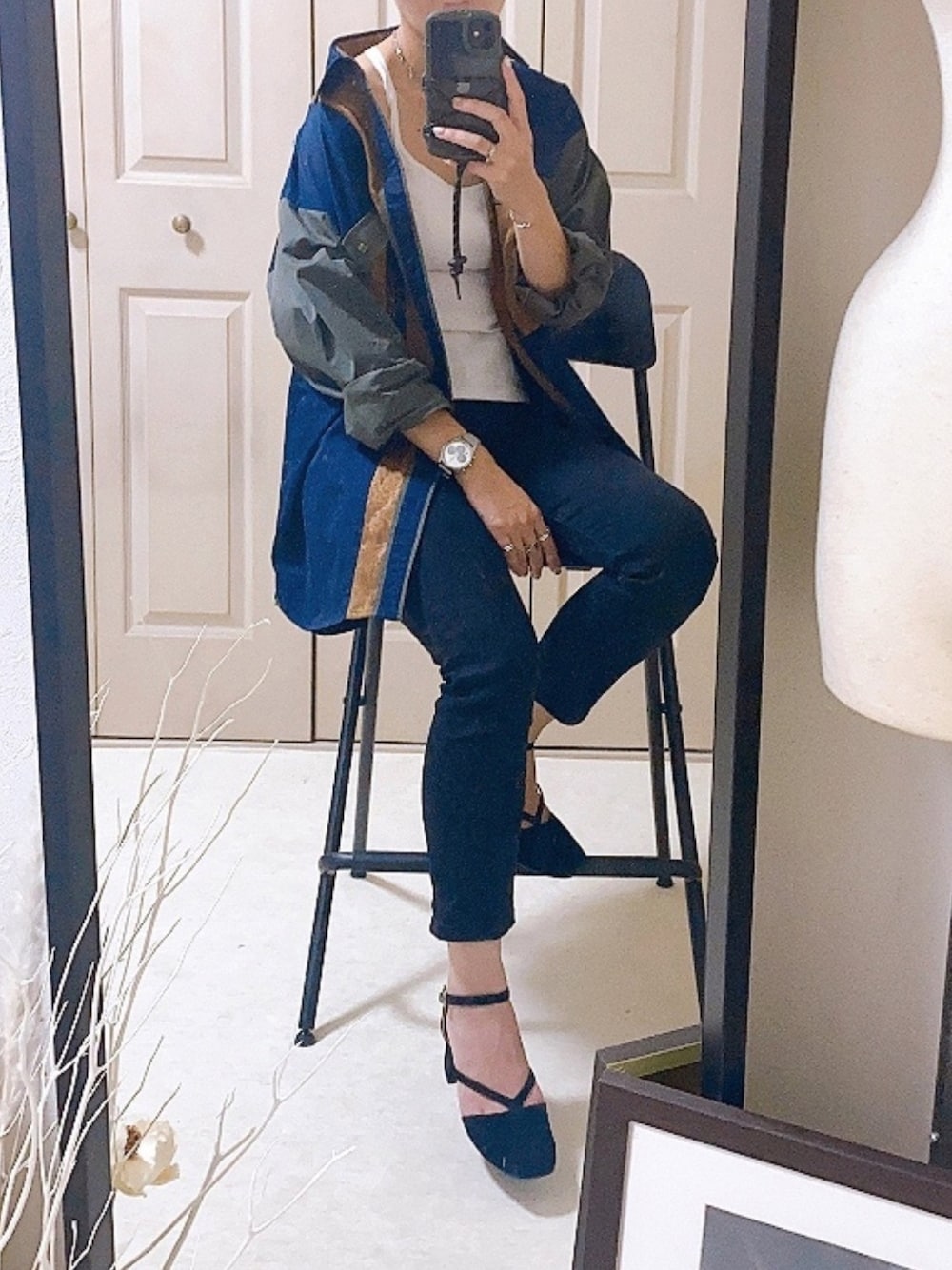 ブラック系のデニムパンツ、ブラック系のパンプス、ブルー系のシャツ/ブラウスを着用したレディースの秋コーディネートの1枚目の写真