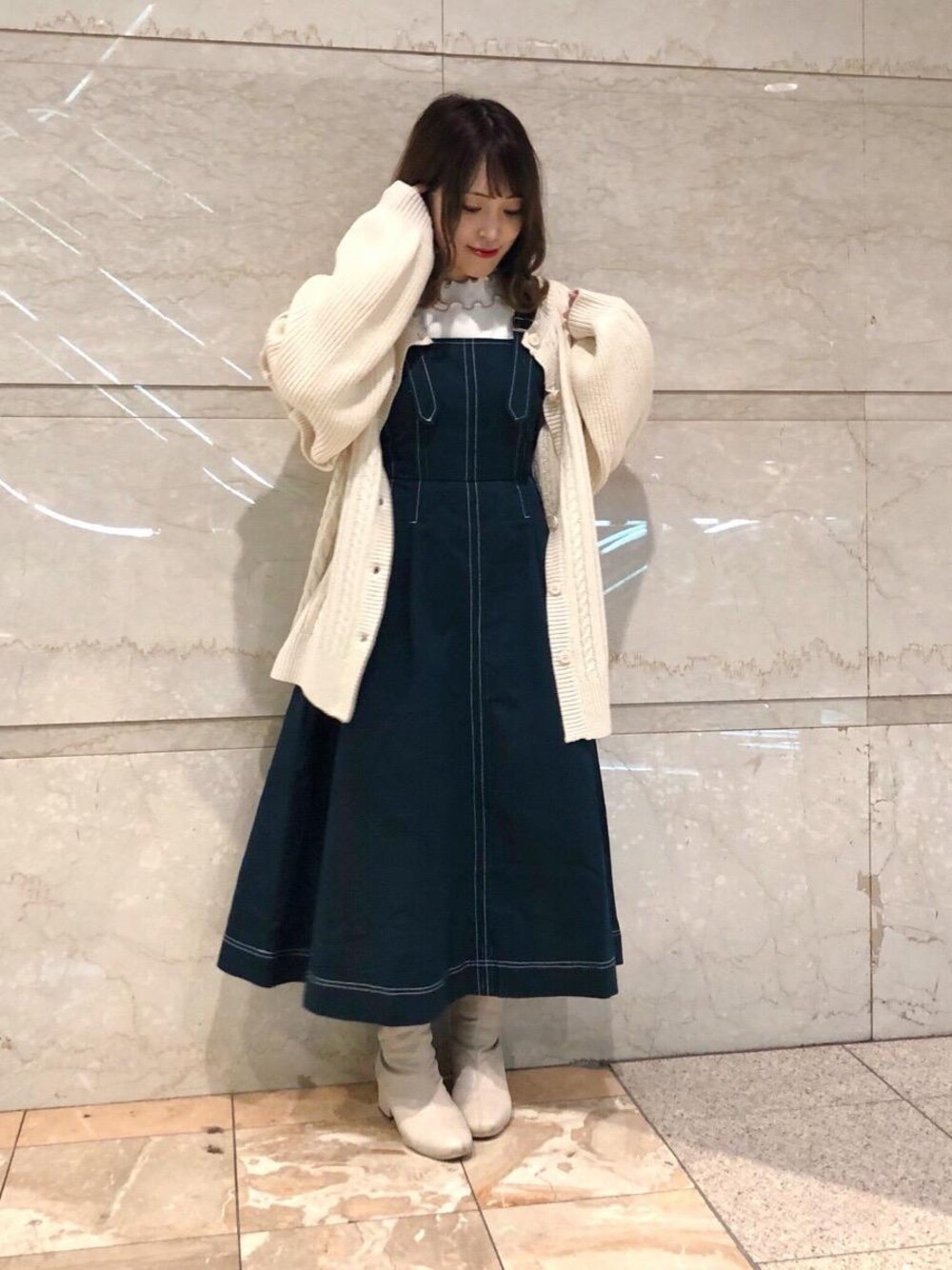 グリーン系のワンピース、ホワイト系のTシャツ/カットソー、ホワイト系のニット/セーターを着用したレディースの冬コーディネートの1枚目の写真