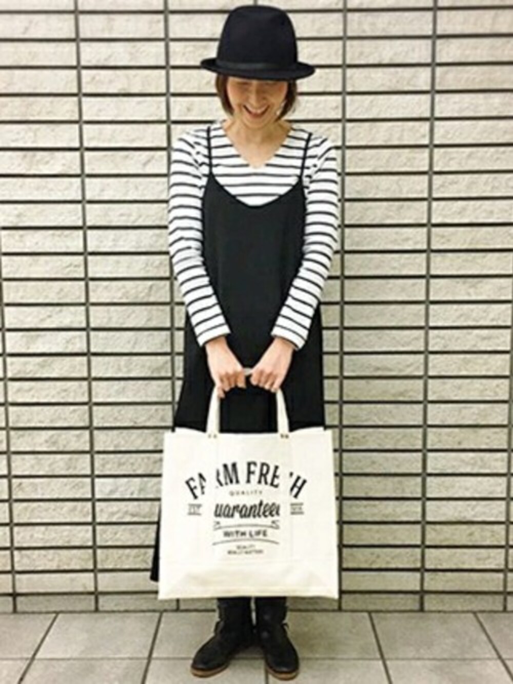 グレー系のサロペット/オーバーオール、ブルー系のTシャツ/カットソー、ベージュ系のトートバッグを着用したレディースの春コーディネートの1枚目の写真