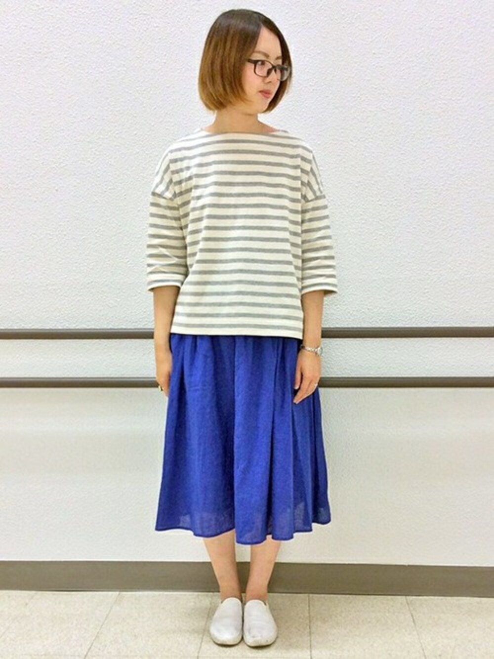 グレー系のTシャツ/カットソー、ブルー系のスカートを着用したレディースの春コーディネートの1枚目の写真
