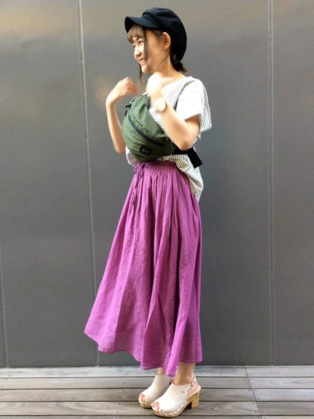 パープル系のスカート、ホワイト系のTシャツ/カットソー、グリーン系のボディバッグ/ウエストポーチを着用したレディースの夏コーディネートの1枚目の写真