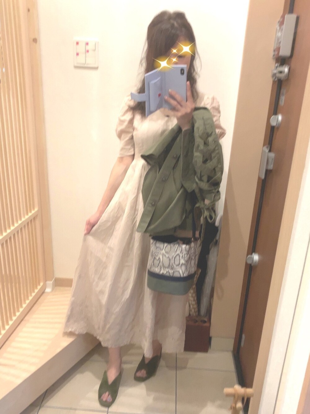 グリーン系のサンダル、グリーン系のショルダーバッグ、ベージュ系のワンピースを着用したレディースの夏コーディネートの1枚目の写真