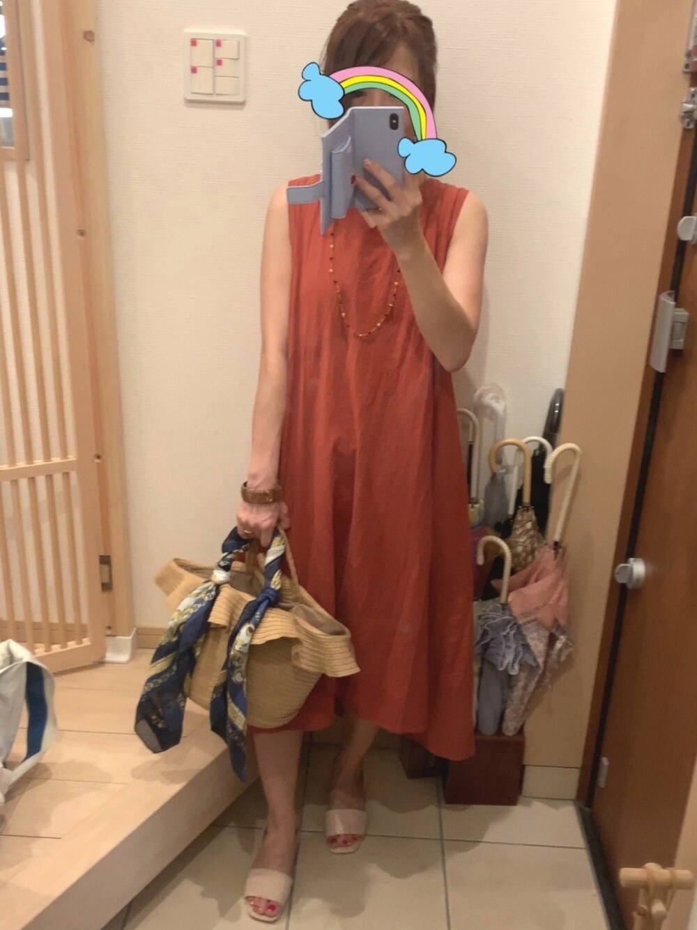 ベージュ系のかごバッグ、ベージュ系のサンダル、オレンジ系のワンピース/ドレスを着用したレディースの夏コーディネートの1枚目の写真