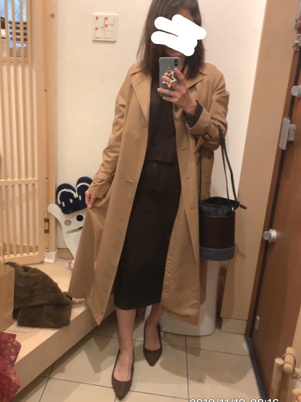 ブラウン系のショルダーバッグ、ブラウン系のトレンチコート、ブラウン系のフォーマルスーツ/小物を着用したレディースの秋コーディネートの1枚目の写真