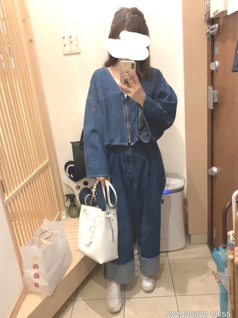 ブルー系のデニムパンツ、ブルー系のデニムジャケット、ホワイト系のトートバッグを着用したレディースの夏コーディネートの1枚目の写真