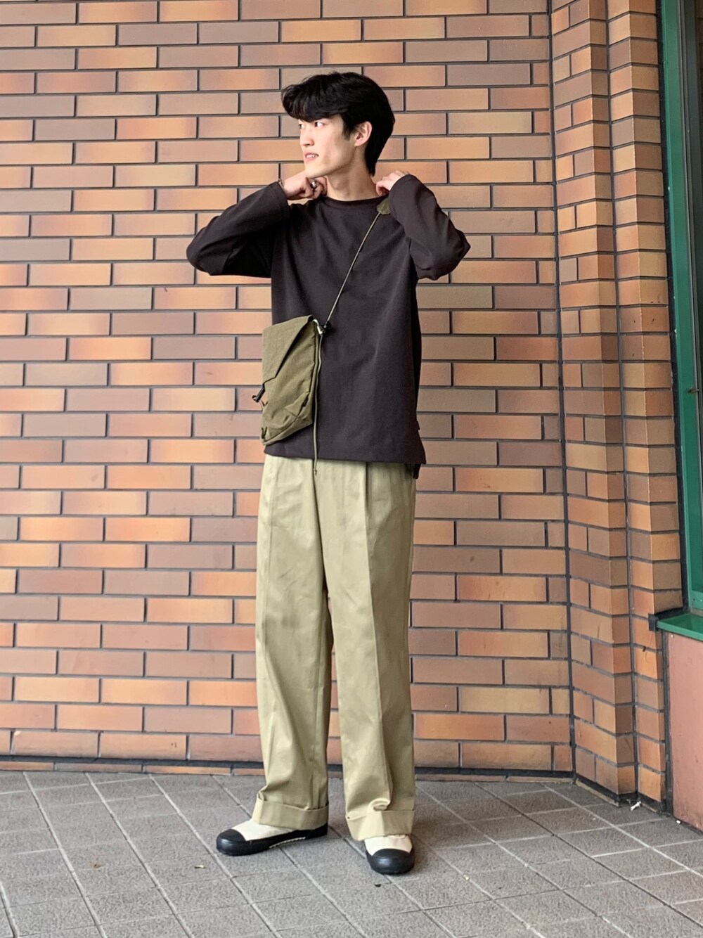 ブラウン系のTシャツ/カットソー、グリーン系のボディバッグ/ウエストポーチ、ベージュ系のスニーカーを着用したメンズの秋コーディネートの1枚目の写真
