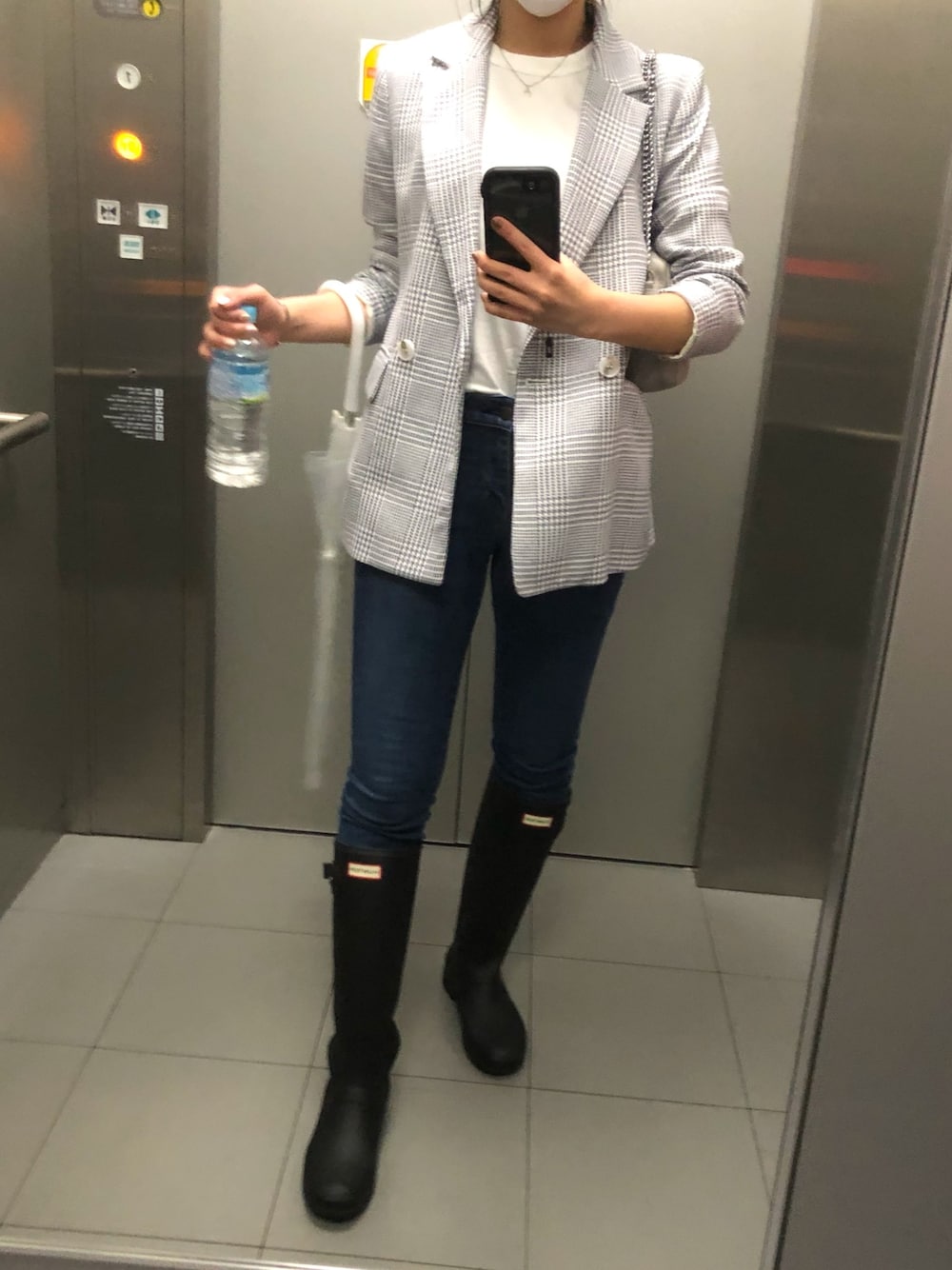 ブラック系のレインシューズ、ブルー系のデニムパンツ、ホワイト系のTシャツ/カットソーを着用したレディースの春コーディネートの1枚目の写真