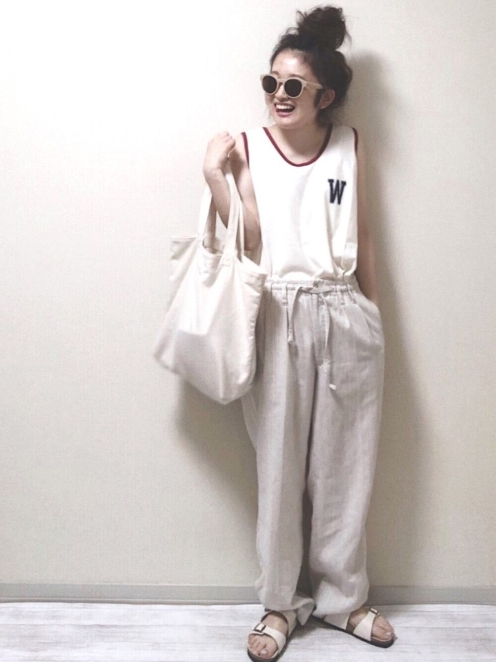 ベージュ系のサンダル、ホワイト系のトートバッグ、ホワイト系のタンクトップを着用したレディースの夏コーディネートの1枚目の写真