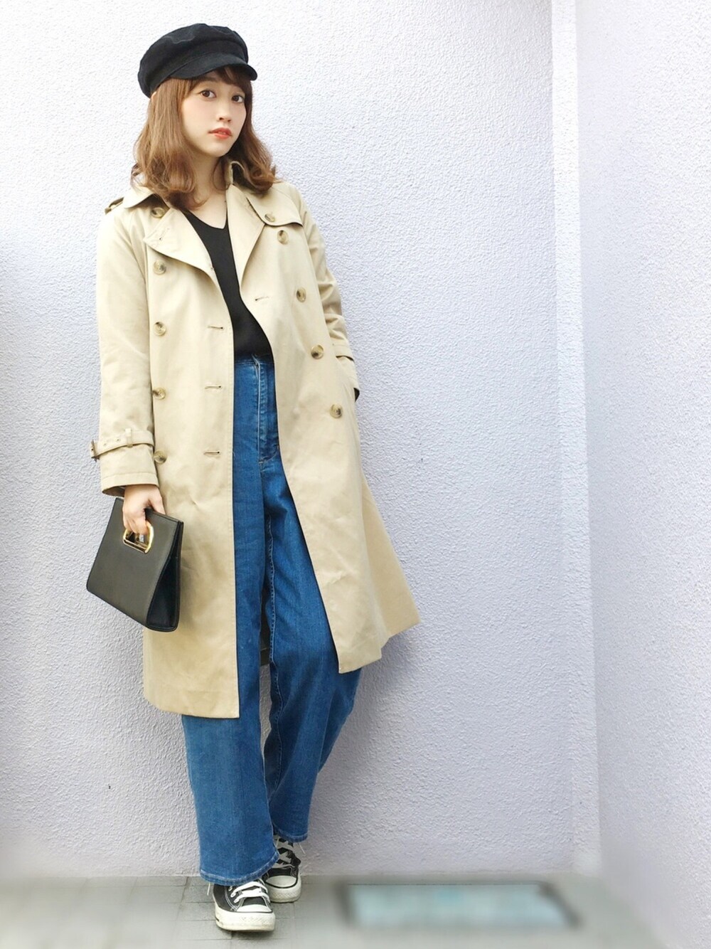 ブラック系のクラッチバッグ、ブラック系のTシャツ/カットソー、ブルー系のデニムパンツを着用したレディースの冬コーディネートの1枚目の写真