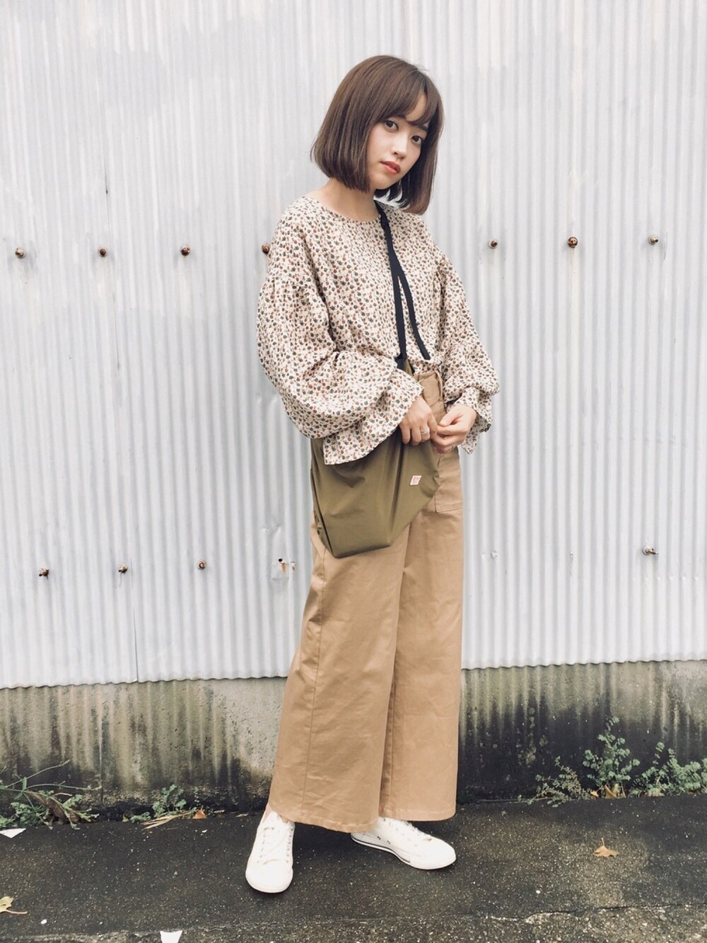 ベージュ系のシャツ/ブラウス、ベージュ系のチノパンツ、グリーン系のショルダーバッグを着用したレディースの秋コーディネートの1枚目の写真