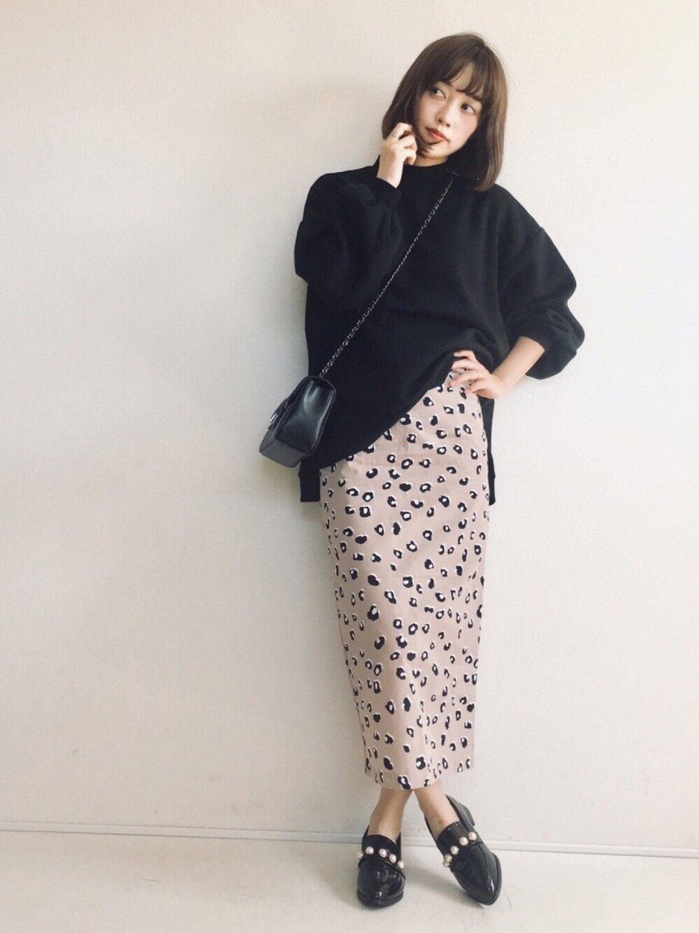 ブラック系のスウェット、ベージュ系のスカート、ブラック系のローファーを着用したレディースの秋コーディネートの1枚目の写真